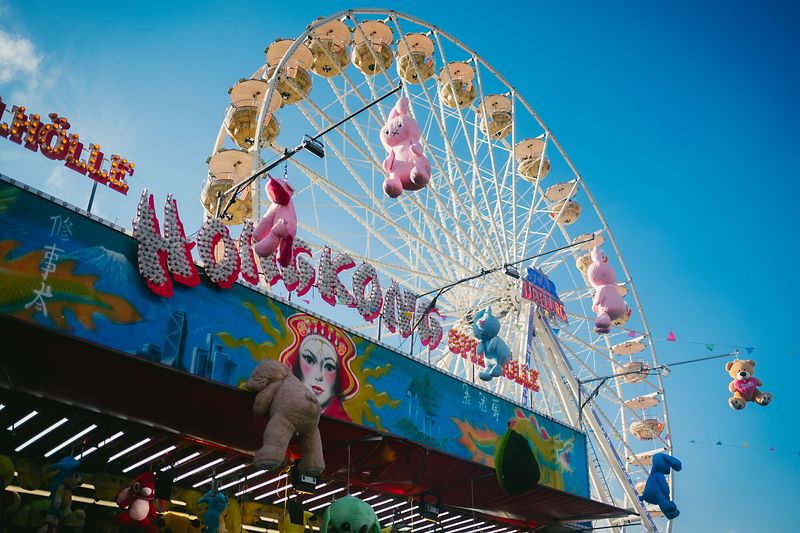Im Vordergrund sieht man einen Teil des Daches eines Standes vom Lüneburger Frühjahrsmarkt. Im Hintergrund ist strahlend blauer Himmel und das Riesenrad zu sehen.