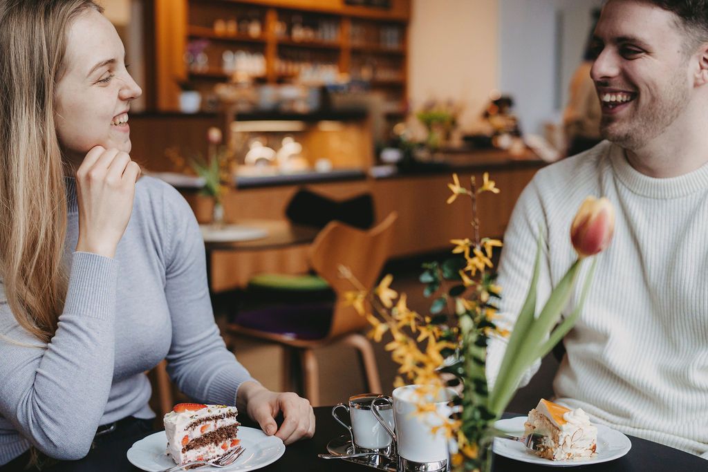 Lachendes Paar am Tisch im Museumscafé LUNA bei Kaffee und Torte.