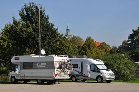 Zwei nebeneinander geparkte Wohnmobile stehen auf dem Wohnmobilstellplatz auf den Sülzwiesen.